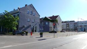 une rue avec des voitures garées sur le côté d'un bâtiment dans l'établissement Rooms Levicki, à Slavonski Brod