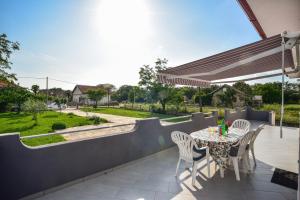un patio con tavolo, sedie e una recinzione di Ankin Dvor a Galovac