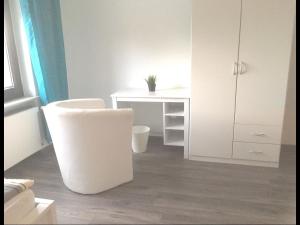 Habitación blanca con escritorio blanco y silla blanca en Ferienwohnung Bellevue, en Staufenberg