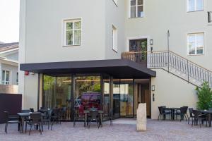 a restaurant with tables and chairs in front of a building at Das Alte Rathaus in Egna