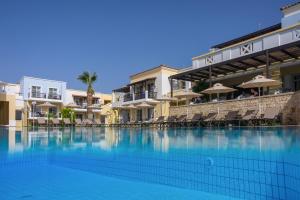 a large swimming pool in front of a hotel at Aegean Houses in Kos