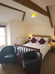 a bedroom with a bed and a pair of chairs at The Olive Branch in Ilfracombe
