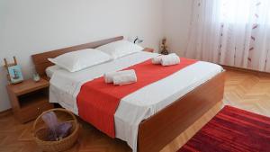 Un dormitorio con una cama grande con una manta roja. en Nora Wine House, en Split