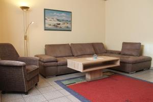 ein Wohnzimmer mit einem Sofa und einem Couchtisch in der Unterkunft Ferienwohnungen im Gästehaus Sieberns in Carolinensiel
