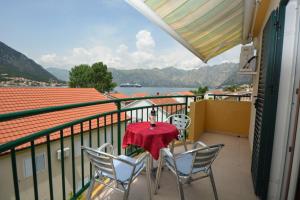 a table and chairs on a balcony with a view at Apartman Milošević in Kotor