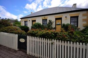 uma casa branca com uma cerca à frente. em Bridge Cottage Sargeants & Armoury Cottages 1823 em Richmond