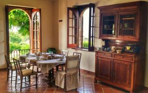 a dining room with a table and chairs and windows at Villa Amalia Srls in Gizzeria