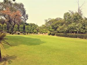 um grande campo de relva com árvores ao fundo em Hotel Samrat, New Delhi em Nova Deli