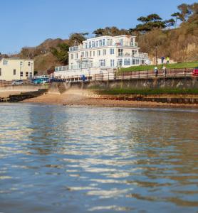 a large white building next to a body of water at Beachside Apartment, 1 Pilots Point in Totland