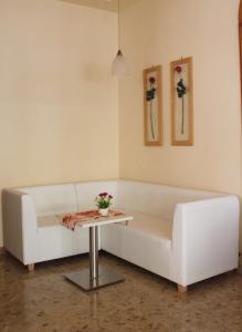 un soggiorno con divano bianco e tavolo di Hotel Eraclea a Lido di Jesolo