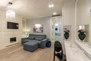 a living room with a blue couch and a tv at Cervia Marina Suite in Cervia
