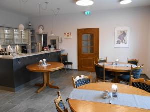 a restaurant with tables and chairs and a counter at Albrecht's Hotel & Restaurant GmbH in Wiedensahl