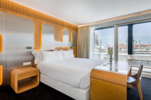 馬德里的住宿－奧斯卡媒介酒店，配有一张床、一张书桌和一扇窗户的酒店客房