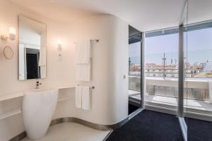 a bathroom with a toilet and a large window at Room Mate Oscar, Madrid in Madrid