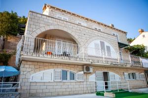 ein Backsteingebäude mit einem Balkon an der Seite in der Unterkunft Apartment Dove with sea view and free parking in Dubrovnik