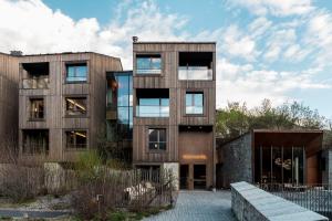 uma casa moderna com uma fachada de madeira e um edifício em Eden Hotel em Bormio