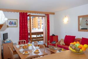 a living room with a table and a dining room at R&eacute;sidence Go&eacute;lia Les Balcons du Soleil in Les Deux Alpes