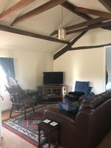 uma sala de estar com um sofá e uma televisão de ecrã plano em The Annexe Croughton em Banbury