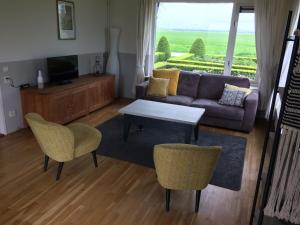 a living room with a couch and a table and chairs at Wide ie Grou in Nes