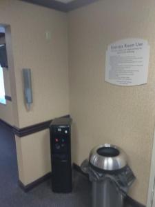 a bathroom with a trash can and a toilet in a room at Baymont by Wyndham Madison Heights Detroit Area in Madison Heights