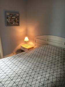 - une chambre avec un lit et une lampe sur une table de chevet dans l'établissement La Falaise, à Mers-les-Bains