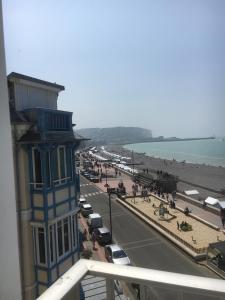 - un bâtiment bleu dans une rue à côté d'une plage dans l'établissement La Falaise, à Mers-les-Bains