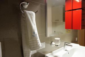 ein Badezimmer mit einem weißen Handtuch auf einem Kleiderständer in der Unterkunft Dominus Residence in Cluj-Napoca