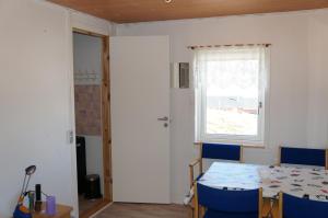 une chambre avec une table, des chaises et une fenêtre dans l'établissement Bed & Breakfast, Oqaatsut/Rodebay, à Oqaatsut