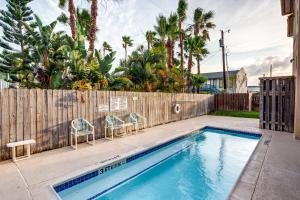 - une piscine avec 2 chaises et une clôture dans l'établissement Cara del Sol #10, à South Padre Island