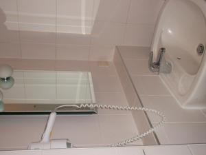 a white shower with a hose in a bathroom at Hotel am Seetor in Angermünde +19 photos
