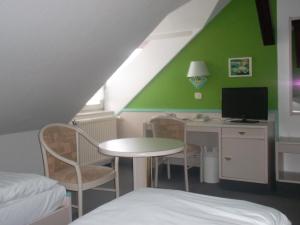 a room with a desk with a computer and a bed at Hotel am Seetor in Angermünde
