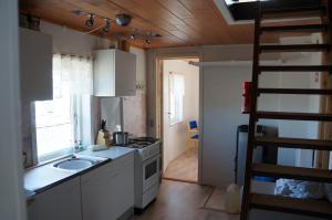 a small kitchen with a sink and a stove at Bed & Breakfast, Oqaatsut/Rodebay in Oqaatsut