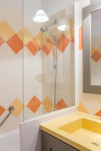 a bathroom with a shower and a yellow sink at Résidence Pierre & Vacances Les Citronniers in Menton