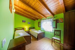 two beds in a room with green walls at Green Hills House in Cefalù