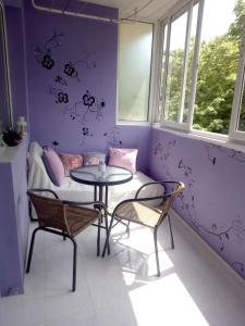 Habitación con mesa, sillas y pared púrpura. en Nana's apartment en Varna