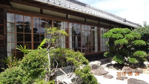 un bâtiment avec des fenêtres et des arbres devant lui dans l'établissement 玉の浦sea, à Nachikatsuura