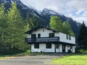StewartBear Valley Guesthouse的白色房子,在山前设有阳台