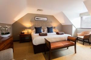 um quarto com uma cama grande e uma cadeira em Barnham Broom Hotel, Golf & Spa em Norwich
