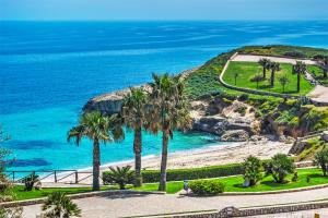 a view of a beach with palm trees and the ocean at Aligiò in Porto Torres