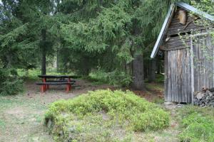 a picnic table and a bench in the woods at Chata Čučka in Pribylina