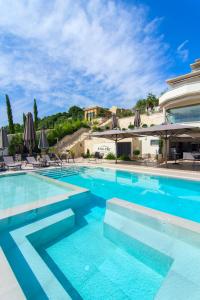 a large swimming pool with chairs and umbrellas at Prima Vista Boutique Hotel & Spa in Sivota