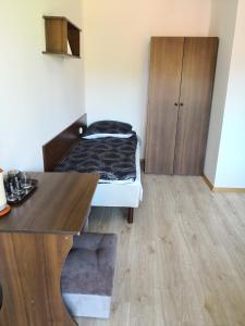ウェバにあるPokoje wakacyjne - Wizygranのベッドとデスクが備わる小さな客室です。