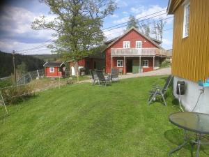 a yard with chairs and a red house at Hagen in Vennesla