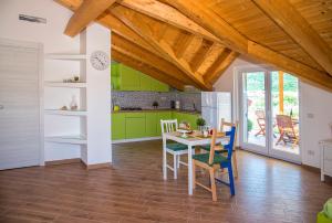 a kitchen with green cabinets and a table and chairs at Fili d'Erba Cilento in Villammare