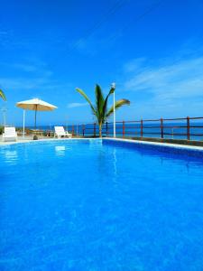 a large blue swimming pool next to the ocean at Bella Vista condominio in Canoas De Punta Sal