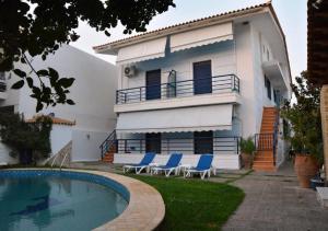 a house with a swimming pool in front of it at Kamari Beachfront Apartments in Xylokastro