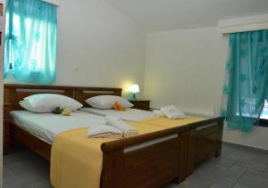a bedroom with two twin beds with blue curtains at Kamari Beachfront Apartments in Xylokastro +29 photos