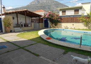 a swimming pool in a yard with a house at Kamari Beachfront Apartments in Xylokastro