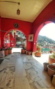 una habitación con una pared roja con macetas en YMCA Tourist Hostel Shimla, en Shimla