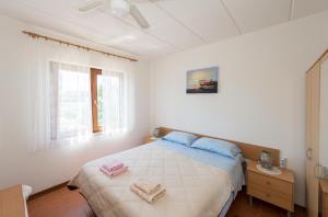 een witte slaapkamer met een bed en een raam bij Apartment Meridiana in Rovinj